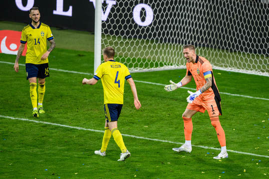 goalkeeper Robin Olsen reacts towards Joakim Nilsson of Sweden