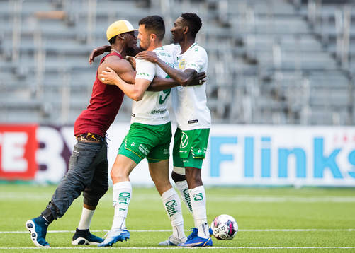 En åskådare tar sig in och kramar om Hammarbys Astrit Selmani och Bubacarr Trawally