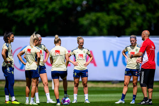 Players of the Swedish women's national football team gather around Magnus Wikman, assistant coach at a training session