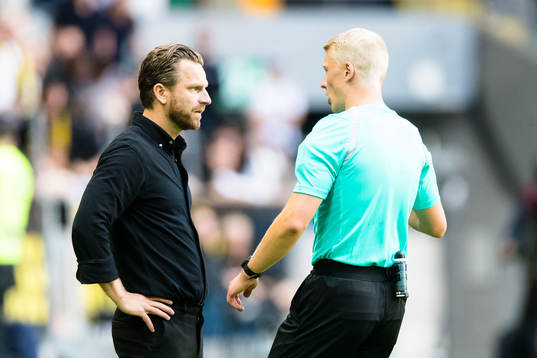s tränare Bartosz Grzelak samtalar med domare Adam Ladebäck under fotbollsmatchen i Allsvenskan mellan AIK och Kalmar den 17 juli 2022 i Stockholm. 