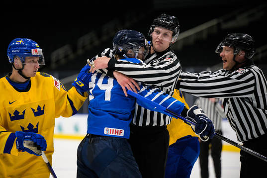 A linesman holds onto Aatu Räty of Finland