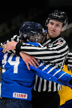 A linesman holds onto Aatu Räty of Finland