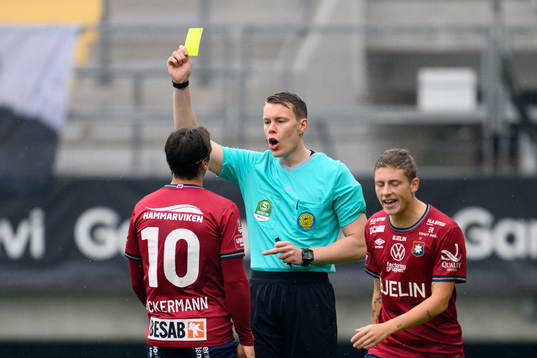 Örgrytes Kevin Ackermann får gult kort av domare Oscar Johnson