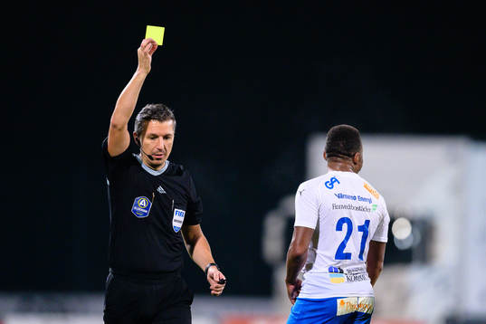 Domare Bojan Pandzic delar ut ett gult kort till Värnamos