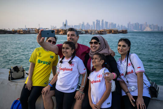 A man takes a selfie with family members at the Corniche