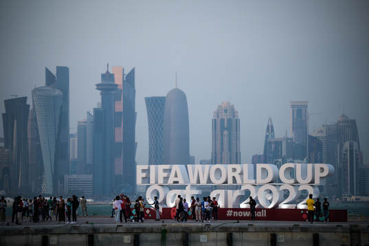 People pose in front of a World Cup logo at Corniche Promenade