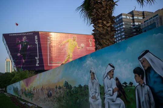 A traditional mural in front of advertising