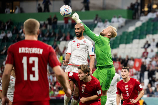 Issam Jebali of Tunisia and goalkeeper Kasper Schmeichel of