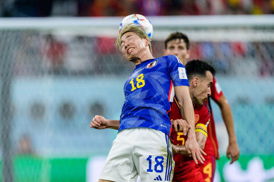 Takuma Asano of Japan and Sergio Busquets of Spain