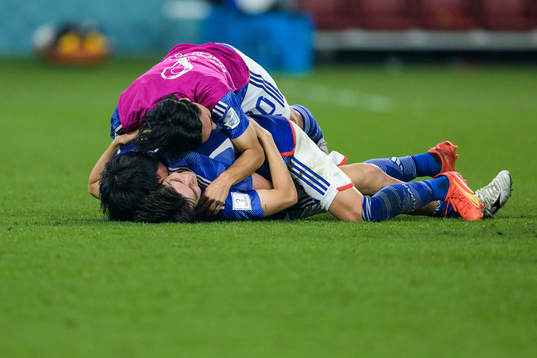 Kaoru Mitoma, Ao Tanaka and Takumi Minamino of Japan celebrate