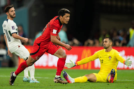 Heechan Hwang of South Korea celebrates the 2-1 goal behind Bernardo Silva and goalkeeper Diogo Costa of Portugal