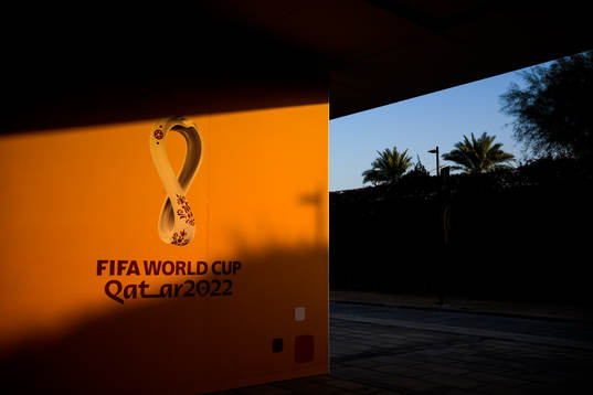 Solen lyser över en FIFA World Cup Qatar 2022-draperad vägg