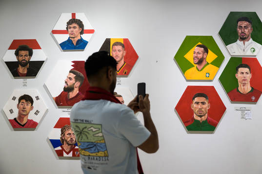 A man shoots video of paintings of football stars