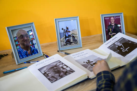 A journalist turn pages in a condolence book for the