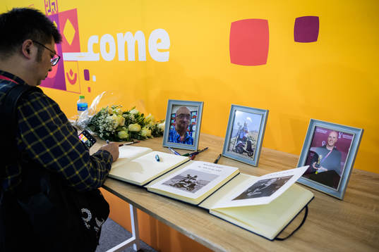 A journalist writes in a condolence book for the members of