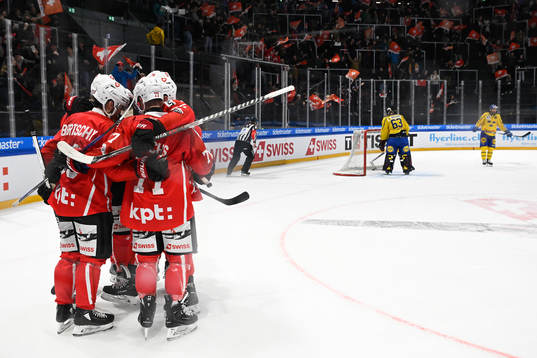 Dean Kukan of Switzerland celebrate with team mates