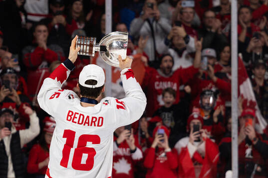 Connor Bedard of Canada celebrates with the trophy