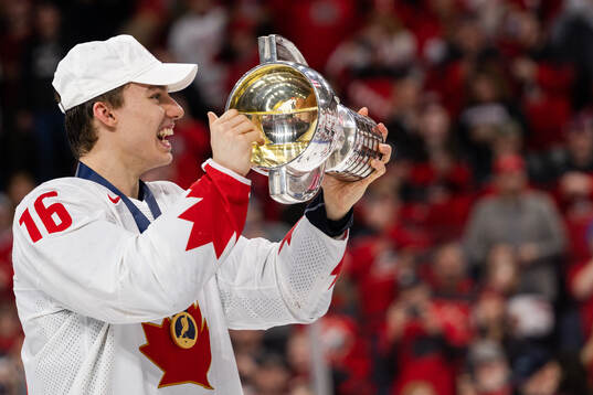 Connor Bedard of Canada celebrates with the trophy