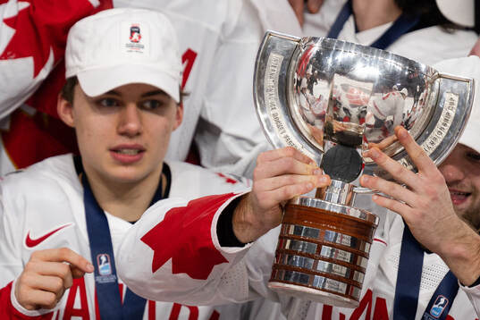 Connor Bedard of Canada celebrates with the trophy