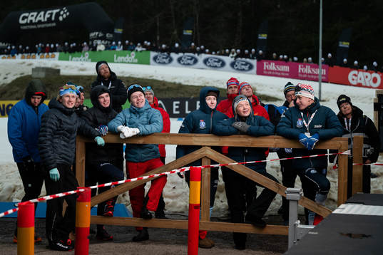 Åkare följer en semifinal i sprint på storbildsskärm