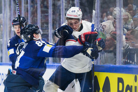 Kaapo Kakko of Finland tackles Lane Hutson of USA
