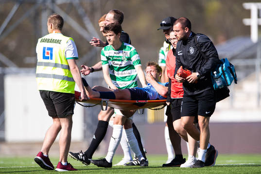 Landskronas Philip Andersson har ont bredvid Västerås SKs Olle Edlund och bärs ut på bår