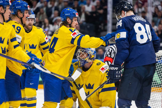Jonathan Pudas of Sweden push Kaapo Kakko of Finland in