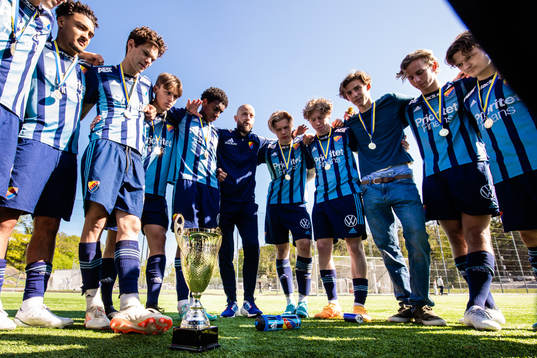 Djurgårdens Gideon Granström (v), Philip Rolke, Theoharis Patjas, Isak Alemayehu Mulugeta, tränare Johan Palm (m), Jack Tagesson, Tom Dahlin, Otto Levin, Oskar Löfström och Jakob Bäckström (h) med pokalen