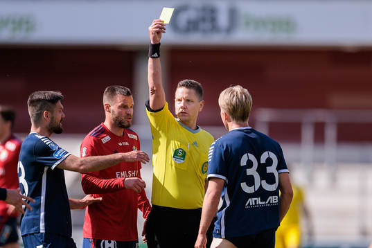 Domare Martin Strömbergsson delar ut ett gult kort till