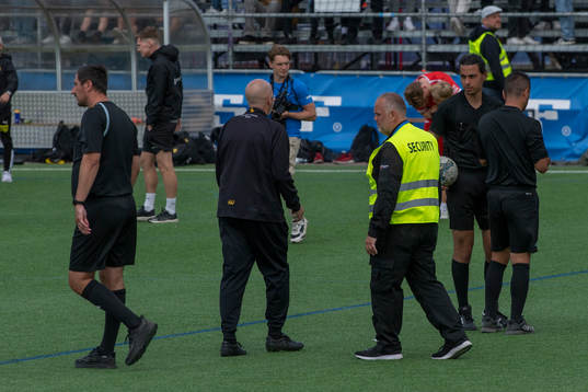 Säkerhetspersonal följer domartrion