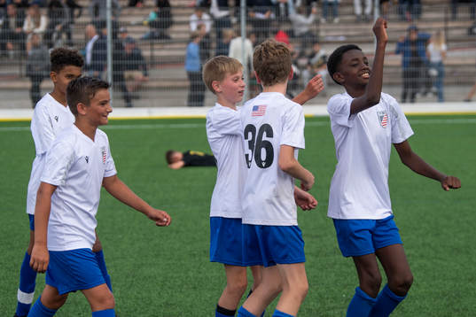 Spelare i  FC New England B12 jublar efter seger