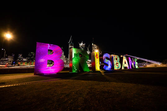 Lit up letters that read ”Brisbane”  is seen in front of the city skyline
