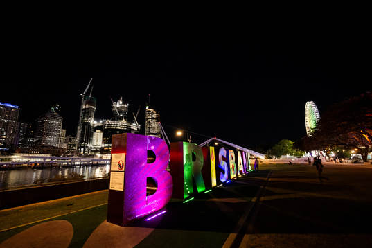 Lit up letters that read ”Brisbane”  is seen in front of the city skyline