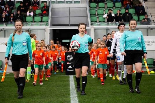 Spelare gör entré med domare Sara Wiinikka, assisterande