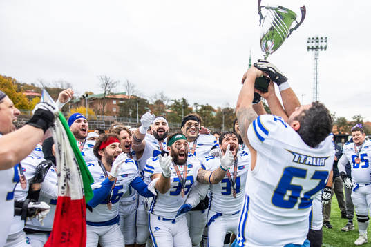 Michael Gentili and Lorenzo Gioco see Stefano Chiappini of Italy celebrate with the trophy