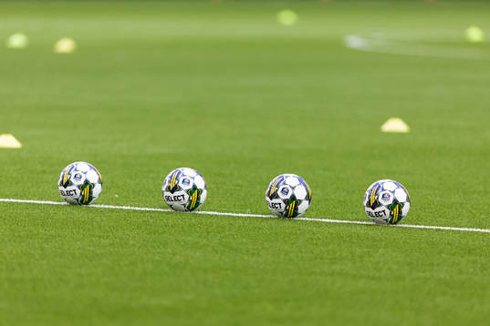 Fyra fotbollar ligger på planen innan fotbollsmatchen i