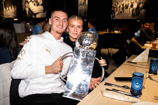 Malmö FFs målvakt Marcus Pettersson med sällskap poserar för en bild med Lennart Johanssons pokal på guldbanketten för att fira SM-guldet