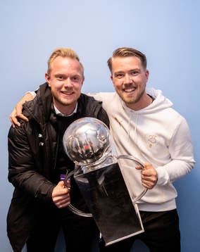 Malmö FFs Max Westerberg och assisterande tränare Theodor Olsson jublar med Lennart Johanssons pokal i omklädningsrummet för att fira SM-guldet