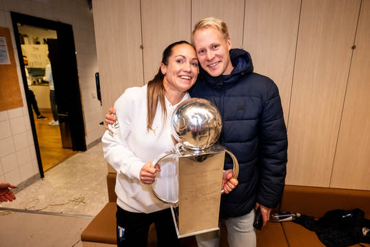 Malmö FFs läkare Amanda Lahti med familj poserar för en bild med Lennart Johanssons pokal i omklädningsrummet för att fira SM-guldet