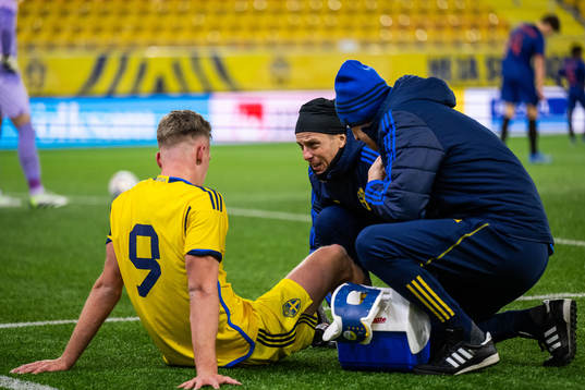 Joel Voelkerling Persson of Sweden is seen to by medical doctor Fredrik Bergström