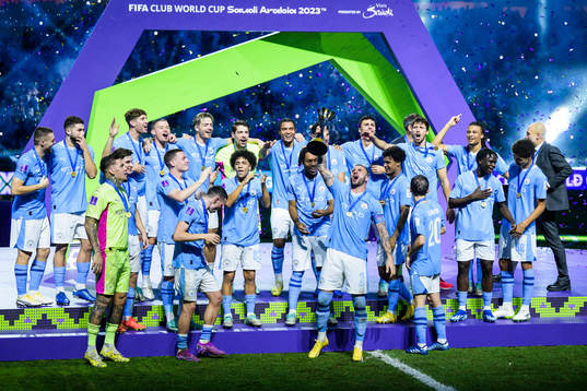 Players of Manchester City celebrate with the trophy