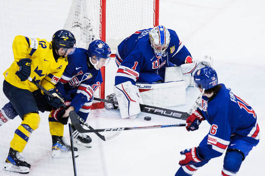 Noah Östlund of Sweden against Lane Hutson and goaltender