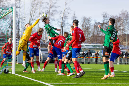 Tvååkers målvakt Albin Svensson boxar bort bollen framför Varbergs Joakim Lindner