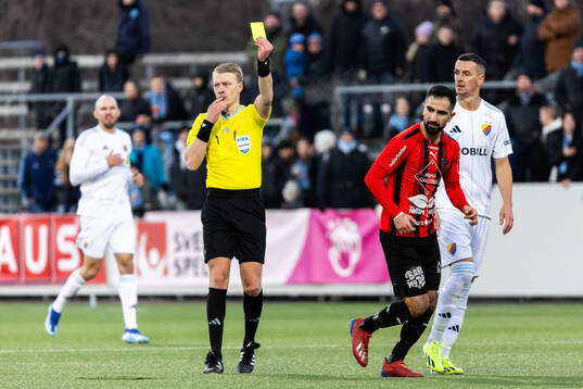 Domare Adam Ladebäck delar ut ett gult kort till Nordic Uniteds Gabriel Aphrem