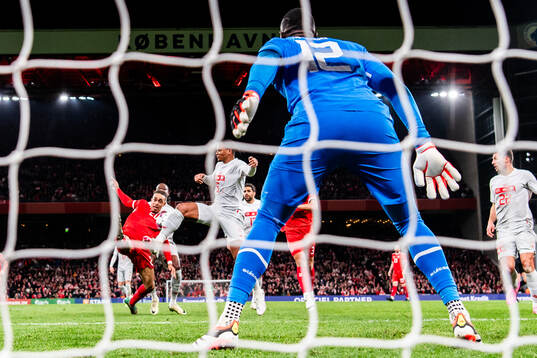 Yussuf Poulsen of Denmark in action against Manuel Akanji and goalkeeper Yvon Mvogo of Switzerland