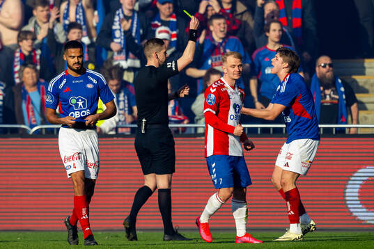 Mees Rijks of Vålerenga receives his second yellow card for a red card by referee Espen Eskås