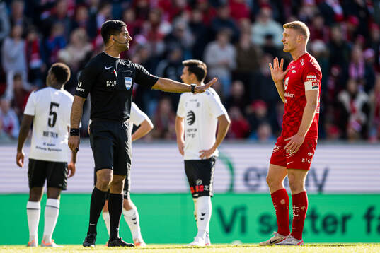 Mohammad Usman Aslam, referee, and Sivert Heltne Nilsen of Brann