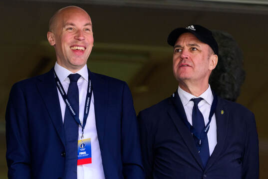 Simon Åström, ordförande i Svensk elitfotboll och Svenska Fotbollförbundets ordförande Fredrik Reinfeldt på läktaren