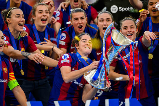 Marta Torrejon of Barcelona lifts the trophy