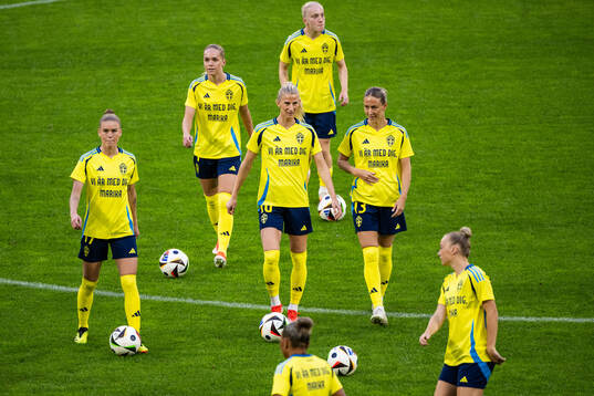 My Cato, Sofia Jakobsson and Emma Kullberg of Sweden, with a warm up shirt dedicated to team manager Marika Domanski Lyfors (not pictured) who was diagnosed with a brain tumor, ahead of the UEFA Women's Euro Qualifying football match between Sweden and Ireland on June 4, 2024 in Stockholm. 
